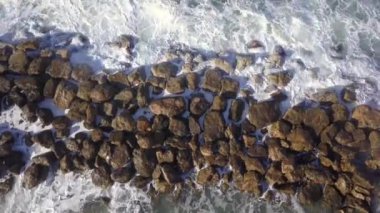 Okyanus dalgaları kış denizinde bir dalgada kırılıyor. Havadan yukarıdan aşağıya görünüm.