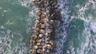 Dalgakıranın üzerinde duran balıkçıların hava manzarası.