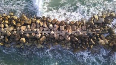 Dalgakıranın üzerinde duran balıkçıların hava manzarası.