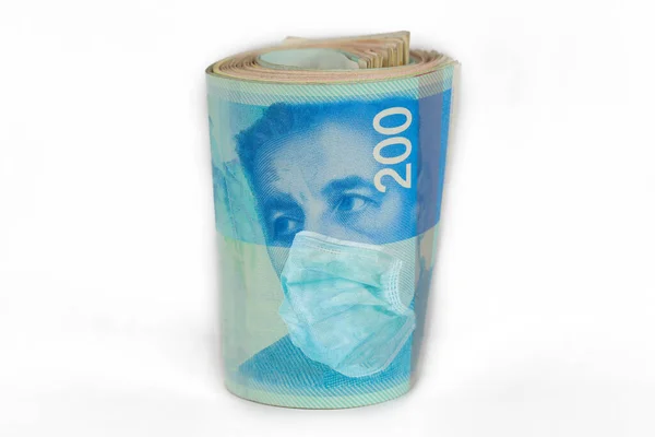 Yüz maskeli 200 NIS para faturası. COVID-19 ISRAEL 'i etkiliyor. Coronavirus Krizi ve Finans Konsepti.