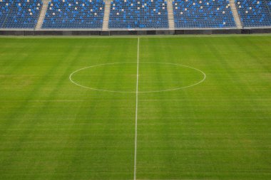 Taraftarların boş bir stadyumdaki futbol sahası.