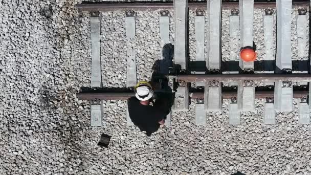 Un ferroviere che ripara un binario rotto. Lavorazione dei metalli. Lavoratori che tagliano binari metallici. — Video Stock