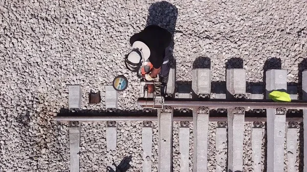 Eisenbahner reparieren ein defektes Gleis. Metallbearbeitung. Arbeiter schneidet Metallschienen. — Stockfoto