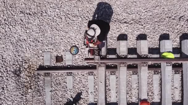 Travailleur ferroviaire réparant une voie ferrée cassée. Travail du métal. Ouvrier coupant des rails métalliques. — Video