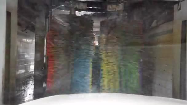 Point de vue du conducteur sur un processus automatique de lavage de voiture dans le tunnel de lavage de voiture. — Video