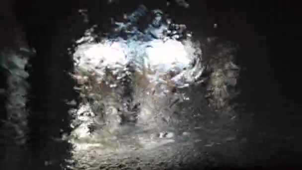 Förarens synvinkel på en automatisk biltvättprocess vid biltvättstunneln. Tvättmaskin med tvål och vatten, roterande borste i automatisk biltvätt. — Stockvideo