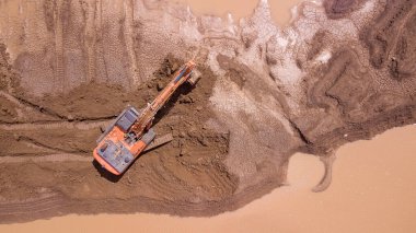 Kazı makinesi, yeni bir inşaat alanının ıslak topraklarında çalışıyor. Bariyer inşaatı.