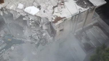  Yeni inşaat için bir binanın yıkımı. Kazıcı yeni inşaat projesi için barakaları yıkıyor. 