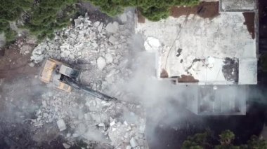 Kazıcı yeni inşaat projesi için barakaları yıkıyor. 