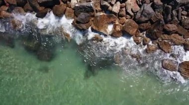 Sakin deniz dalgaları bir dalgakırana çarpar. Hava görünümü.