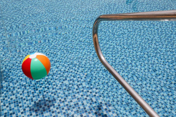 Grab bars ladder in a blue swimming pool.