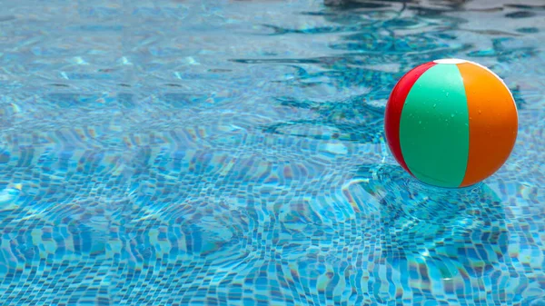 Bola de praia na piscina. Bola inflável colorida que flutua na piscina. — Fotografia de Stock