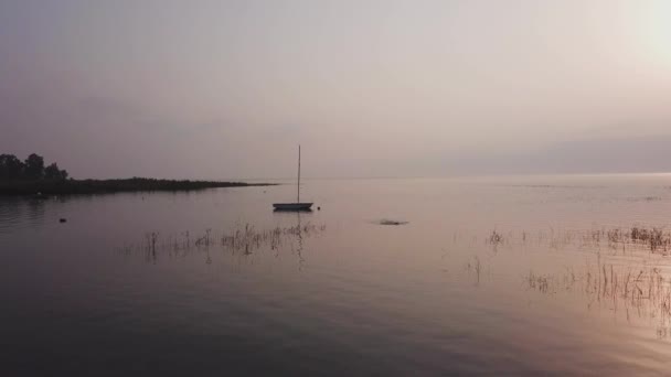 Nascer do sol sobre o lago. Barco flutuando na água calma sob o pôr do sol incrível. — Vídeo de Stock