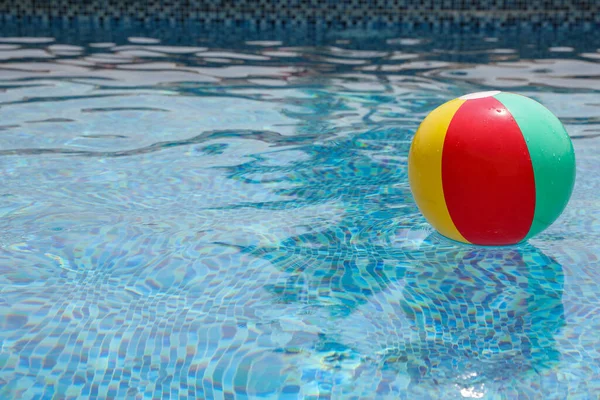 Bola de praia na piscina. Bola inflável colorida que flutua na piscina, conceito das férias do verão. — Fotografia de Stock