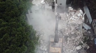 Kazıcı yeni inşaat projesi için barakaları yıkıyor. 