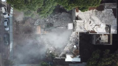 Kazıcı yeni inşaat projesi için barakaları yıkıyor. 