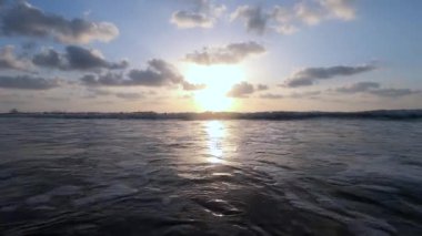 Okyanus dalgaları. Gün batımında sakin dalgalar alçak bir bakış açısından.