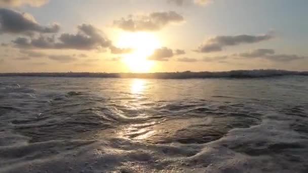 Okyanus dalgaları. Gün batımında sakin dalgalar alçak bir bakış açısından. Su kamera lensine çarptı.. — Stok video