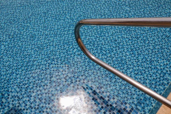 Pegue barras escada em uma piscina azul. — Fotografia de Stock
