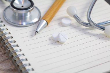 Sağlık kontrolü için. Haplar ve ofis malzemeleri ahşap masada.