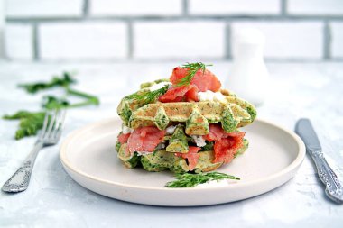 Hafif akşam yemeği, öğle yemeği, seramik tabakta tuzlanmış somon ve krem peynirli ıspanaklı waffle.