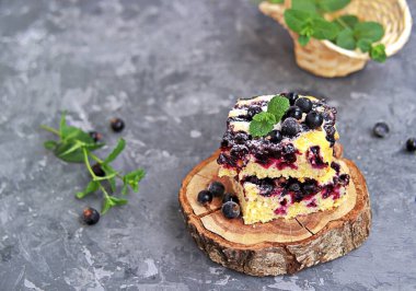Mısır unu ve siyah frenk üzümlü tatlı dilimlenmiş kek. Taze nane, pudra şekeri ve donmuş siyah frenk üzümü meyveleriyle süslenmiş..