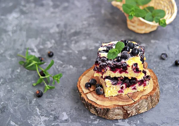 Mısır unu ve siyah frenk üzümlü tatlı dilimlenmiş kek. Taze nane, pudra şekeri ve donmuş siyah frenk üzümü meyveleriyle süslenmiş..