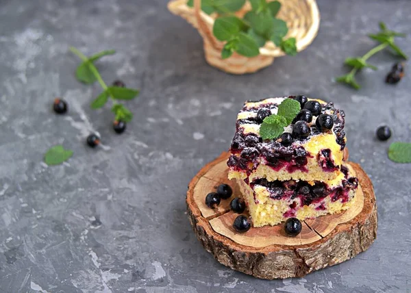 Mısır unu ve siyah frenk üzümlü tatlı dilimlenmiş kek. Taze nane, pudra şekeri ve donmuş siyah frenk üzümü meyveleriyle süslenmiş..