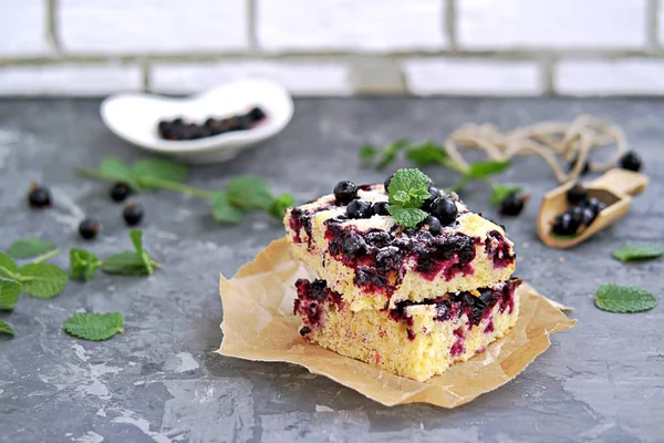 Mısır unu ve siyah frenk üzümlü tatlı dilimlenmiş kek. Taze nane, pudra şekeri ve donmuş siyah frenk üzümü meyveleriyle süslenmiş..