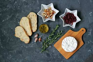 Pişirilmiş camembert peyniri, kurutulmuş kızılcık, taze biberiye, zeytin yağı, sarımsak, ceviz, tost için beyaz ekmek. Üst görünüm, alanı kopyala.