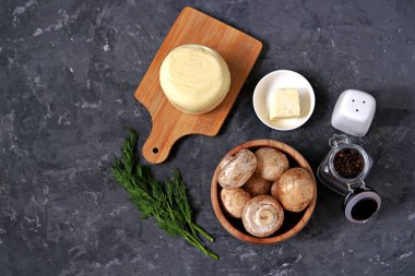 Koyu gri arka planda suluguni ile pişmiş şampiyonlar pişirmek için gerekenler: Üst görünüm.