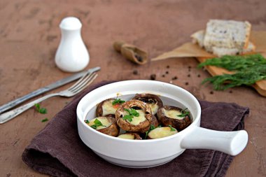 Sıcak aperatif, beyaz seramik formda suluguni peynirli fırında mantar. Gürcistan mutfağı.