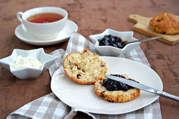 传统的英式烤饼 白盘上有干红莓 配上果酱和奶油 — 图库照片