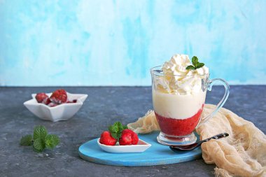 Tatlı, bir tabaka donmuş çilek ve cam kadehte krem şantili sıcak beyaz çikolata. Taze nane yapraklarıyla süslenmiş. Boşluğu kopyala.