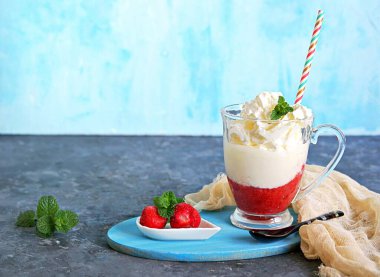 Tatlı, bir tabaka donmuş çilek ve cam kadehte krem şantili sıcak beyaz çikolata. Taze nane yapraklarıyla süslenmiş. Boşluğu kopyala.