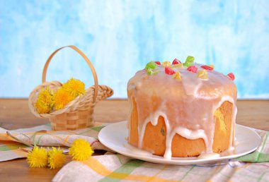 Beyaz tabakta geleneksel paskalya pastası, şekerli ve şekerli meyvelerle süslenmiş. Mutlu Paskalyalar.