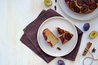 Dilimlenmiş ballı kek ya da açık beton arka planda açık rende taze erikli kek. Erikli ürünler. Şükran Günü.