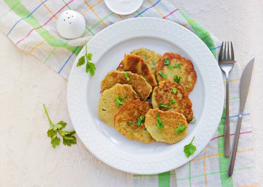 Geleneksel patates krepleri, arka planda hafif bir beton üzerine beyaz bir tabakta çiğ patateslerden yapılır. Beyaz Rusya mutfağı. Patates Tarifi. Ekşi kremayla servis edilir..