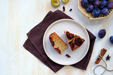 Dilimlenmiş ballı kek ya da açık beton arka planda açık rende taze erikli kek. Erikli ürünler. Şükran Günü.