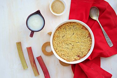 Tatlı, hafif beton arka planda beyaz cam şeklinde raventli çıtır çıtır. Muhallebi ile servis edilir. İngiliz mutfağı.