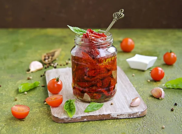 自家製の太陽は オリーブグリーンのコンクリートの背景にガラス瓶にトマトを乾燥させました 収穫だ イタリア料理 — ストック写真