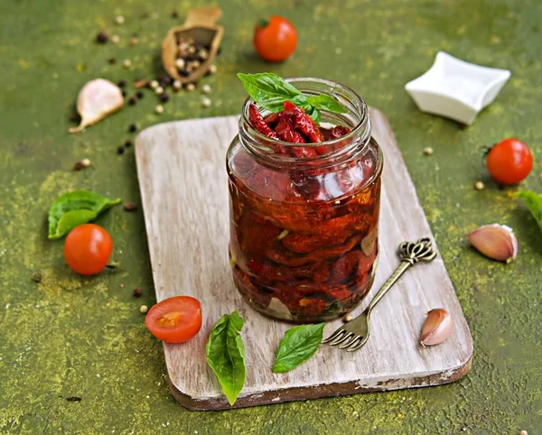 自家製の太陽は オリーブグリーンのコンクリートの背景にガラス瓶にトマトを乾燥させました 収穫だ イタリア料理 — ストック写真