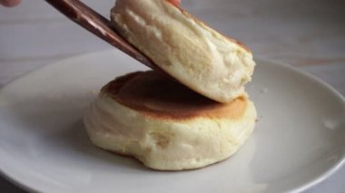 Kabarık sufle krepleri beyaz tabakta şerbetle doluyor.