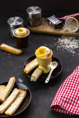 Özel bir yumurta kabında rafadan yumurta ve kızarmış ekmek ile basit bir köy kahvaltısı. Krakerli sarı yumuşak yumurta sarısı.