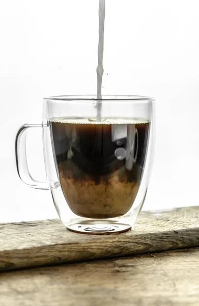 Versare Latte Nel Caffè Nero Tazza Trasparente Sul Tavolo Legno — Foto Stock