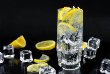 Limon ve buzlu soda, siyah zemin üzerinde beyaz soda, ferahlatıcı soğuk içecek.