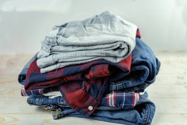 Kirli çamaşır, kot pantolon, ekose gömlek, tişört yığını.