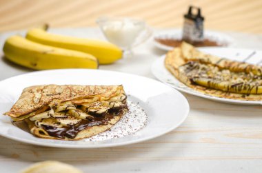 Yulaf unu, muz, çikolata ve fındıklı ev yapımı ince krepler. Sağlıklı yemek, düzgün beslenme kahvaltısı.