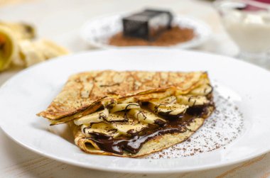 Yulaf unu, muz, çikolata ve fındıklı ev yapımı ince krepler. Sağlıklı yemek, düzgün beslenme kahvaltısı.