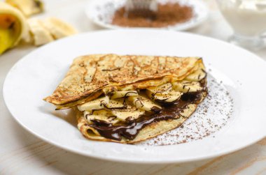 Yulaf unu, muz, çikolata ve fındıklı ev yapımı ince krepler. Sağlıklı yemek, düzgün beslenme kahvaltısı.